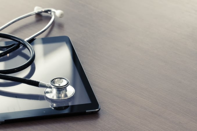 Studio macro of a stethoscope and digital tablet with shallow DOF evenly matched abstract on wood table background copy space.jpeg